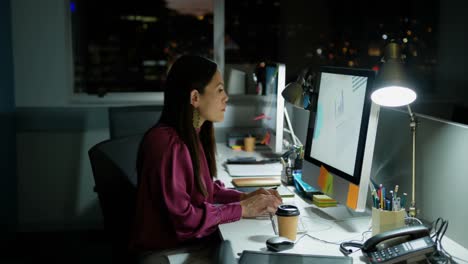 Vista-Lateral-De-Una-Joven-Ejecutiva-Caucásica-Trabajando-En-Una-Computadora-En-El-Escritorio-En-Una-Oficina-Moderna-4k