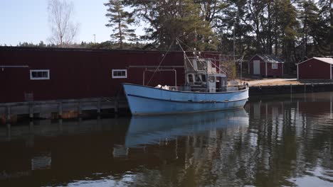 a stationary footage of an old fishing boat docked in a lake in sweden and has been left untouched