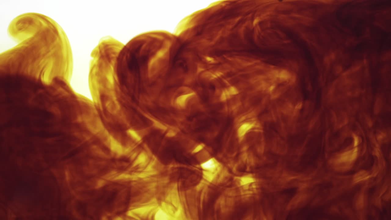 Colorful chemical liquids mix and swirl in water, forming smooth abstract patterns and organic shapes