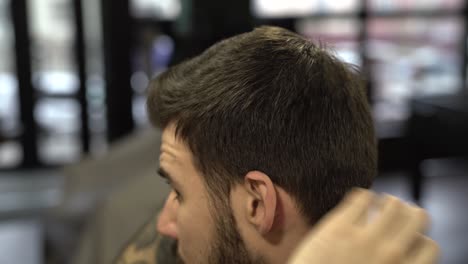 Young-handsome-man-is-making-hairstyle-with-gel-for-himself