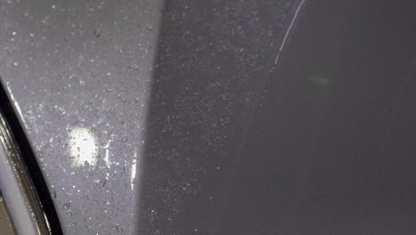 worker uses plastic scraper after applying protection film on car body