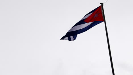 bandera cubana revoloteando en el viento en el poste