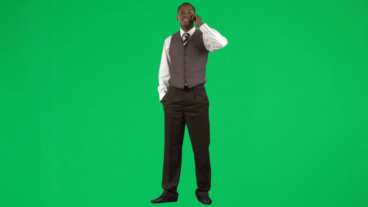 아프리카계 미국인 사업가가 휴대전화로 녹색 스크린 영상을 촬영하고 있습니다.