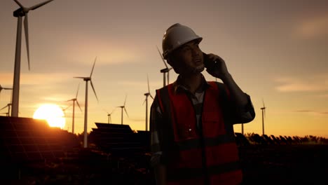 engineer discussing wind and solar farm maintenance at sunset