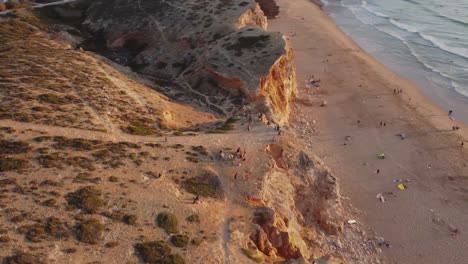 aerial view of a unset on a beach full of surfers in sagres portugal