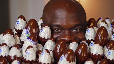 man surrounded by cadbury chocolate eggs