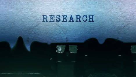 máquina de escribir con la palabra investigación impresa en papel