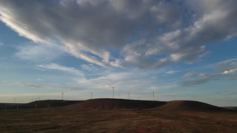 wind farm on rolling hills under a cloudy sky
