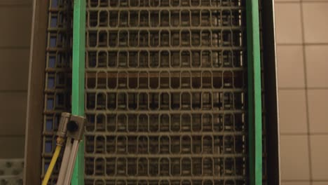 fresh bread moving along conveyor belt in baking tins. top down view