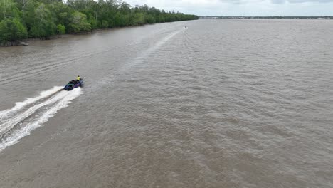 travel shoot with drone speedboat speeding towards agats port, papua, indonesia