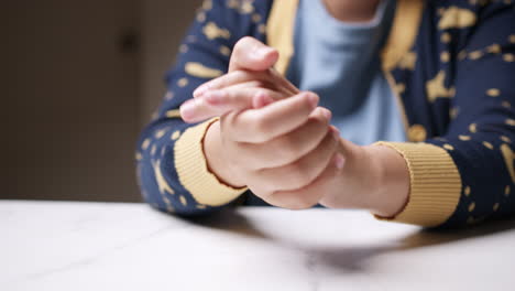 close-up of hands clasped together, as the person is sqeezing and stretching them gently to relieve the pain that the individual is feeling