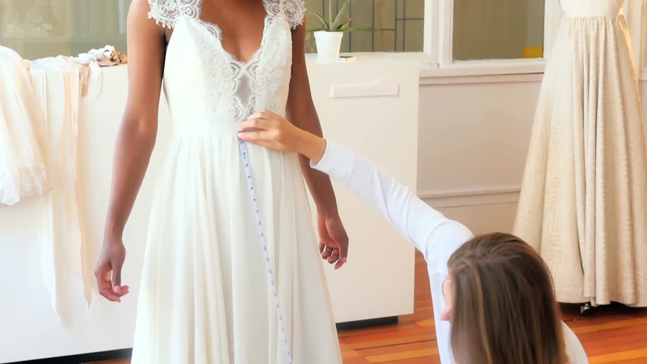 Stilista che prende le misure a una donna