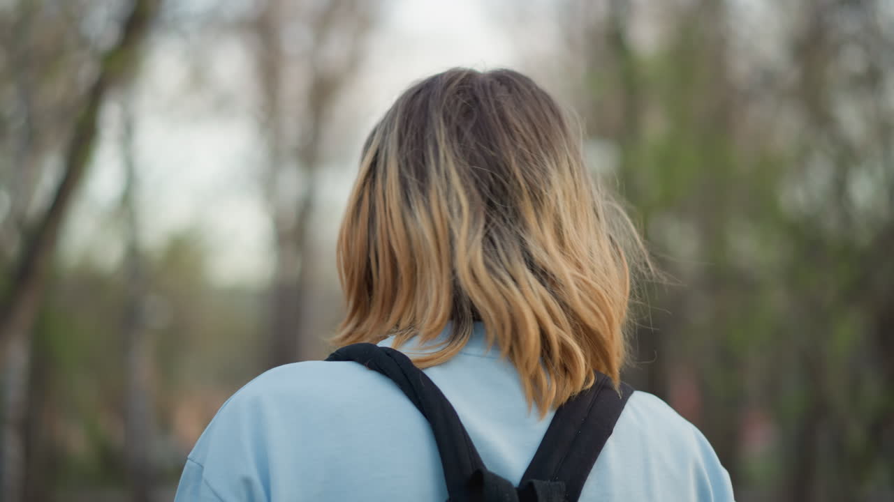 공원에서 백팩을 멘 채 잠시 멈춰 선 흰색 피부의 남성이 옆모습으로 보여요. 나무에 둘러싸인 뒷모습과 어깨는 주변 소리를 들으며 조용히 사색에 잠긴 채 장소를 물색하는 예술가의 모습을 담고 있습니다.