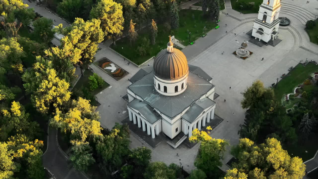Aerial drone view of Chisinau downtown at sunset. View of central park, Cathedral, bell tower, a lot of greenery, walking people. Moldova