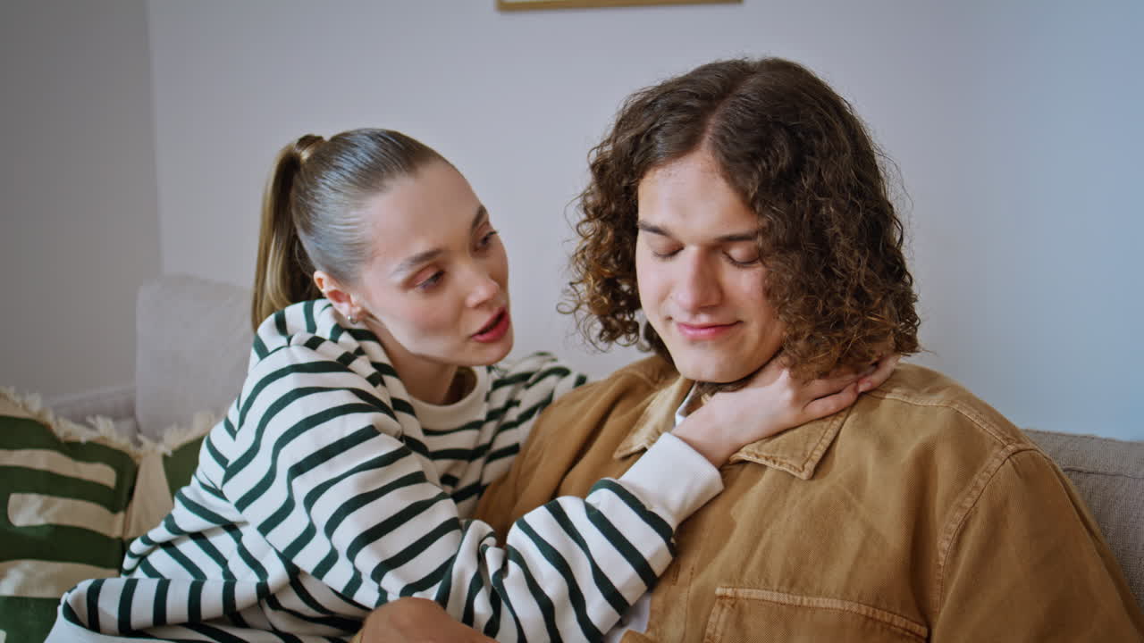 Loving wife talking husband sitting together home couch closeup. Smiling couple