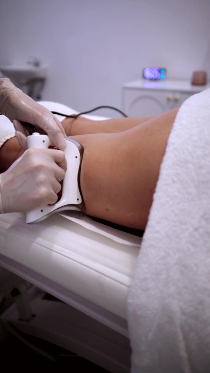 Estetista professionale che esegue un trattamento alle gambe in una clinica estetica