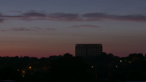 Timelapse-Del-Amanecer-Y-El-Anochecer-Que-Dura-Un-Cuarto-De-Minuto-De-Un-Gran-Edificio-De-Oficinas-En-Un-área-Suburbana-De-Inglaterra