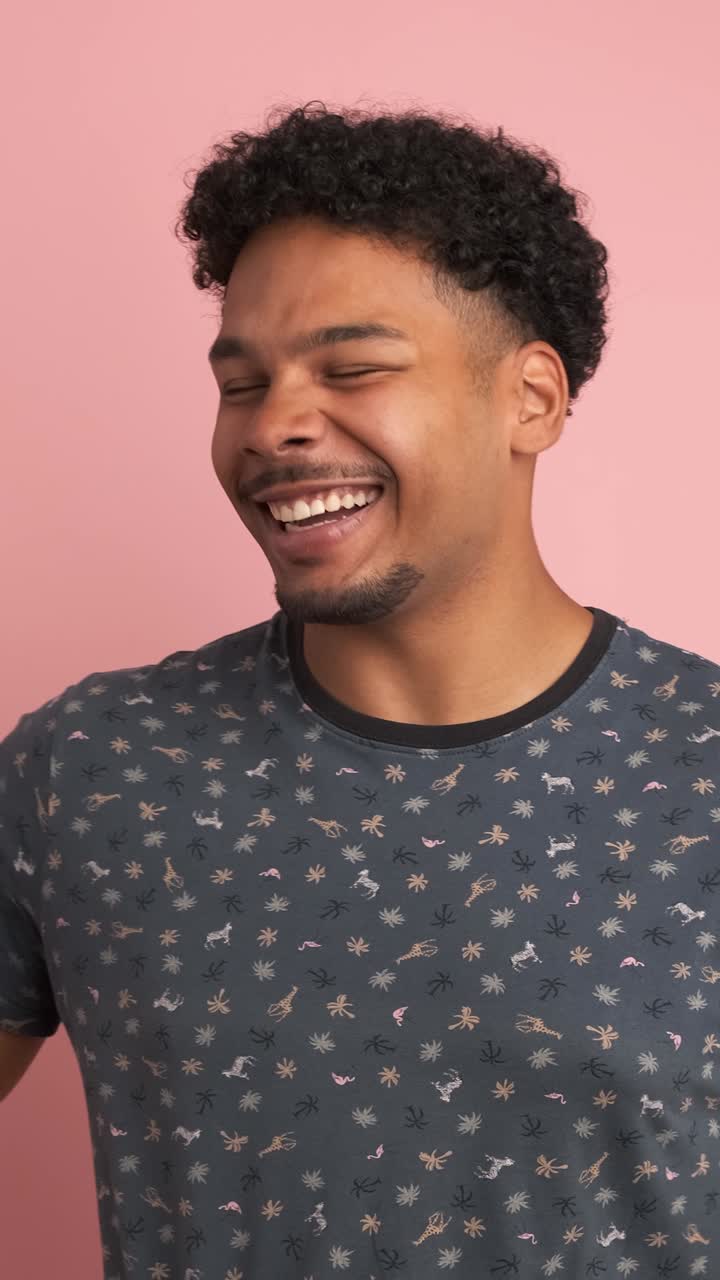 Amused man laughing loudly at funny joke while looking at camera