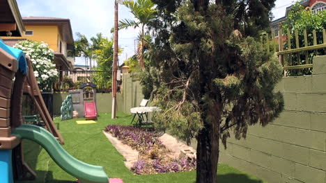patio trasero suburbano con casa de juegos para niños en un día ventoso
