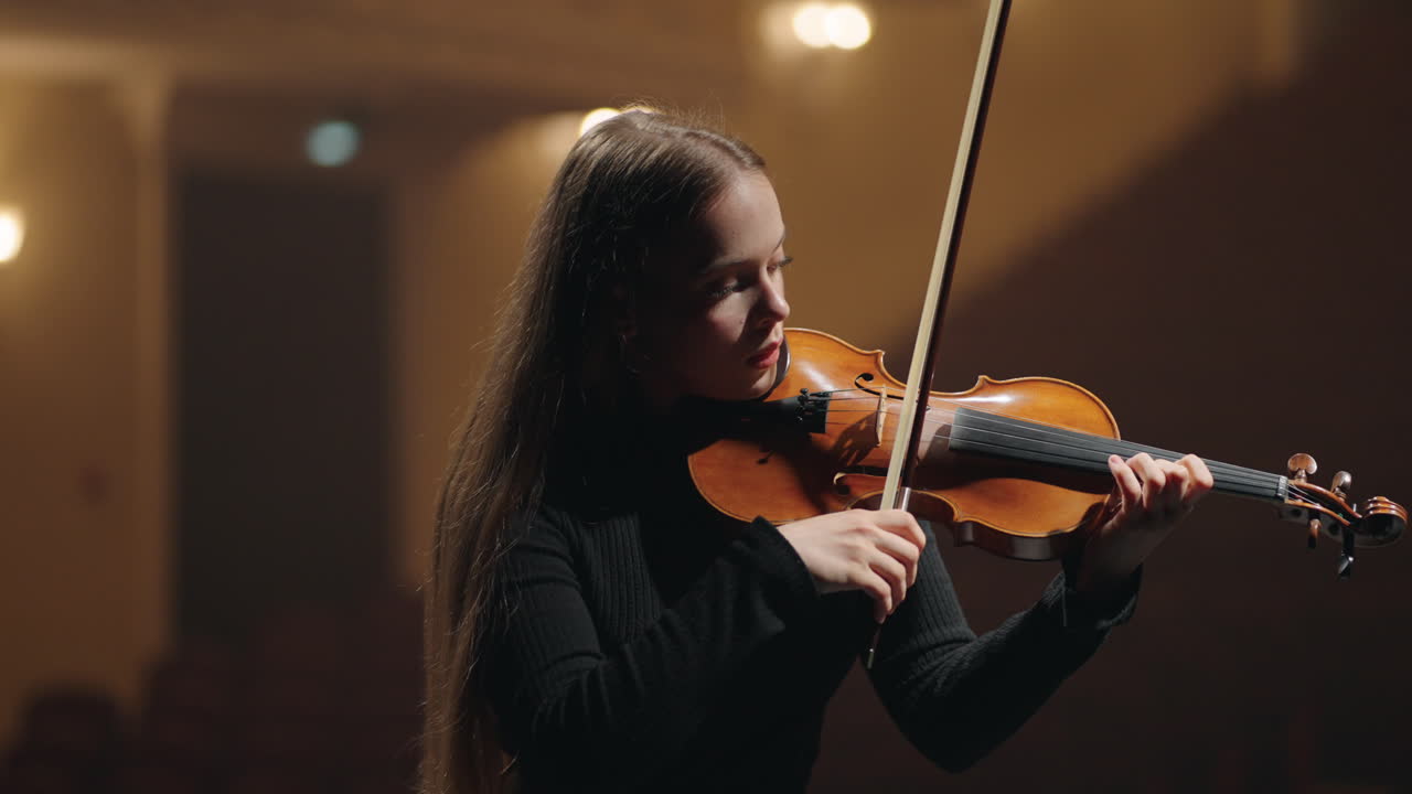 joven estudiante violinista está tocando el violín en la sala de música retrato de una mujer violinista en una orquesta sinfónica