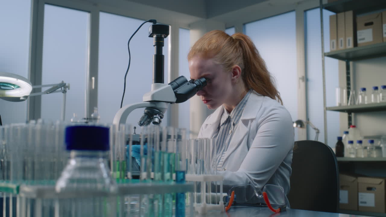 ученый использует микроскоп в лаборатории