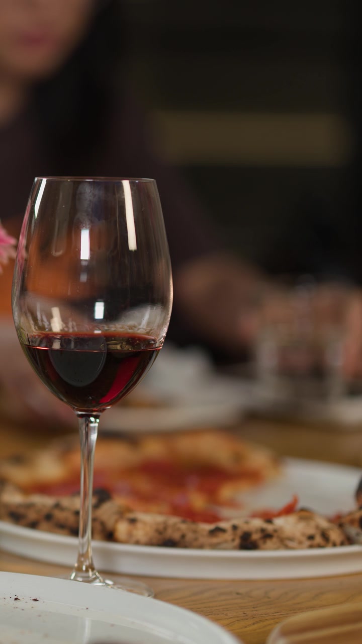 Bicchiere di vino rosso su un tavolo da ristorante con pizza