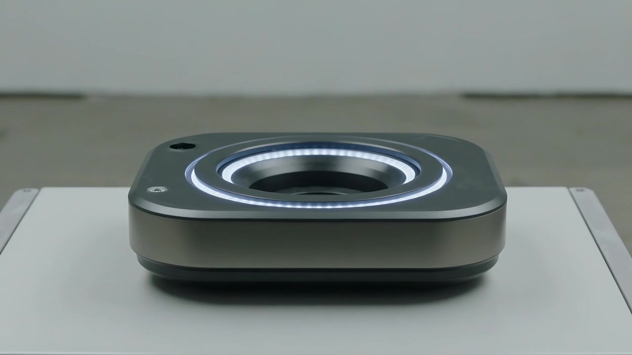 Powering metallic device emitting LED ring on white panel for demo, showing black port and screw