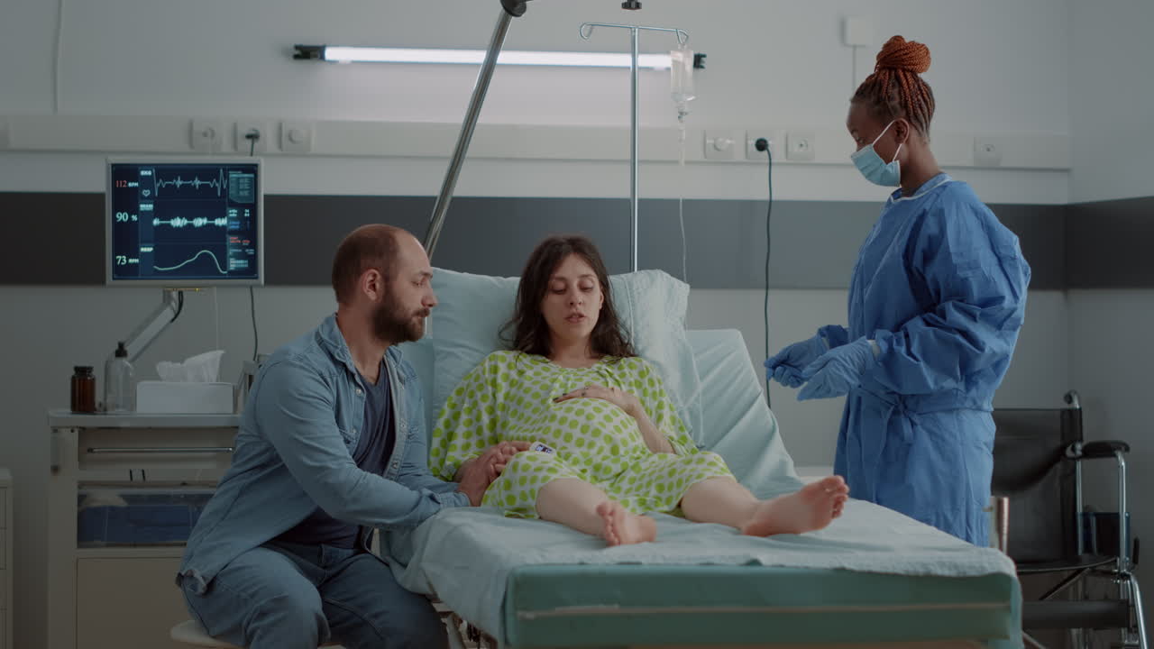 Pregnant patient laying in hospital ward with medical equipment