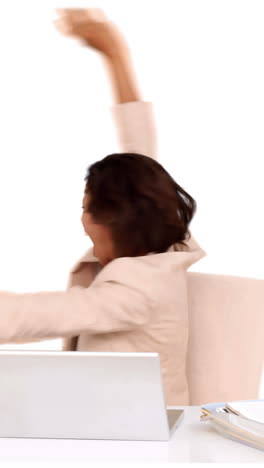 una mujer de negocios celebrando en su escritorio.