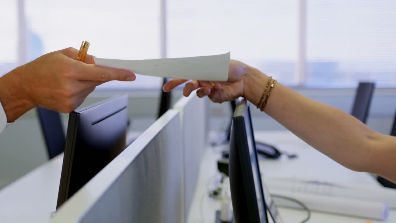 Side view of male executive giving documents to his colleague in modern office 4k
