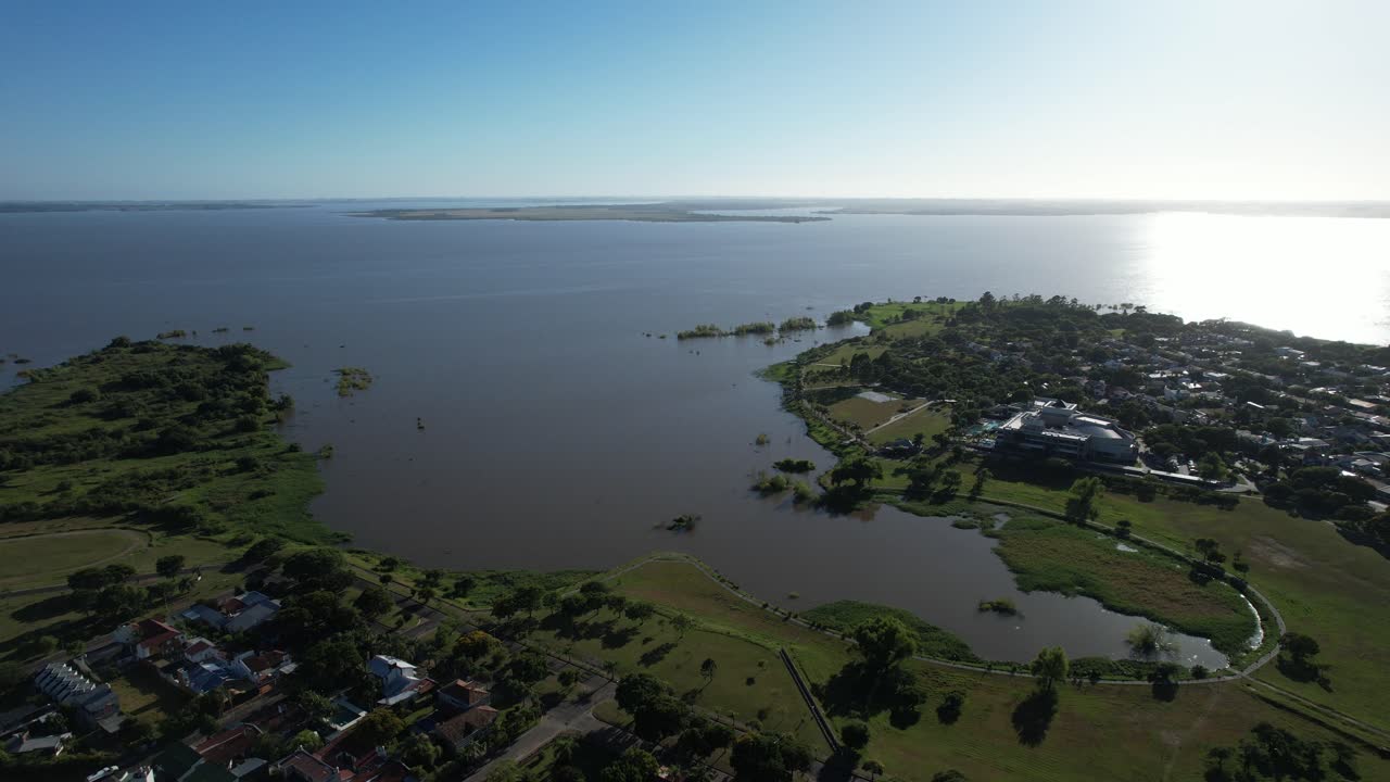 drone raising and lowering the camera in front of the Salto Grande Dam, Federacion, Argentina, soft dawn light with reflection of the sun on the water