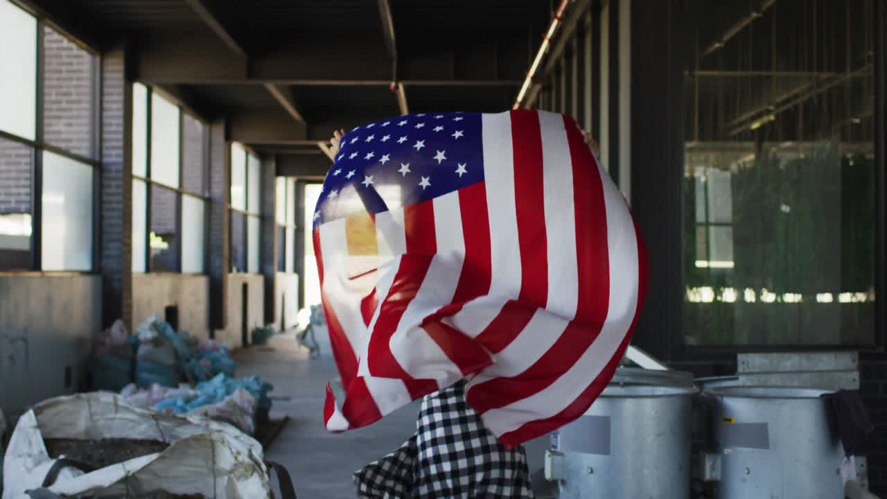 mujer de raza mixta sosteniendo nuestra bandera corriendo a través de un edificio vacío