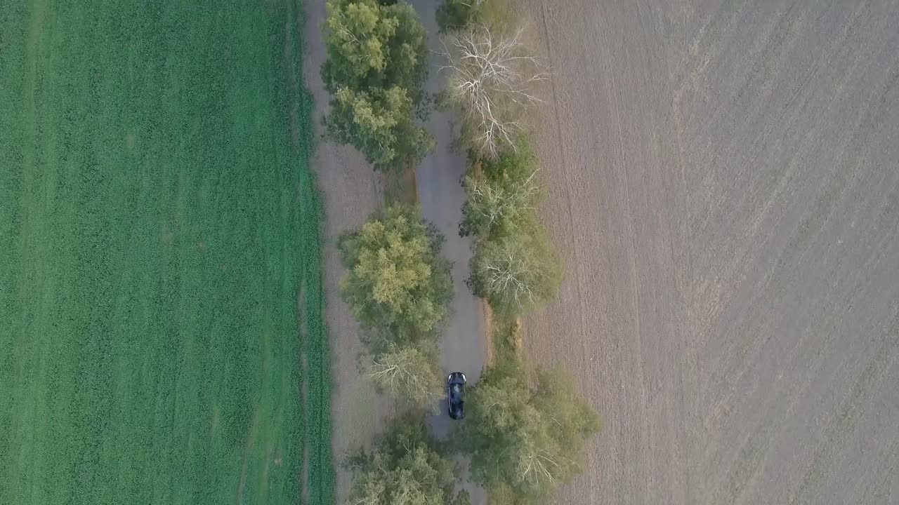 A drone shot of an electromobile driving through the nature