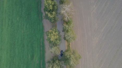 a drone shot of an electromobile driving through the nature