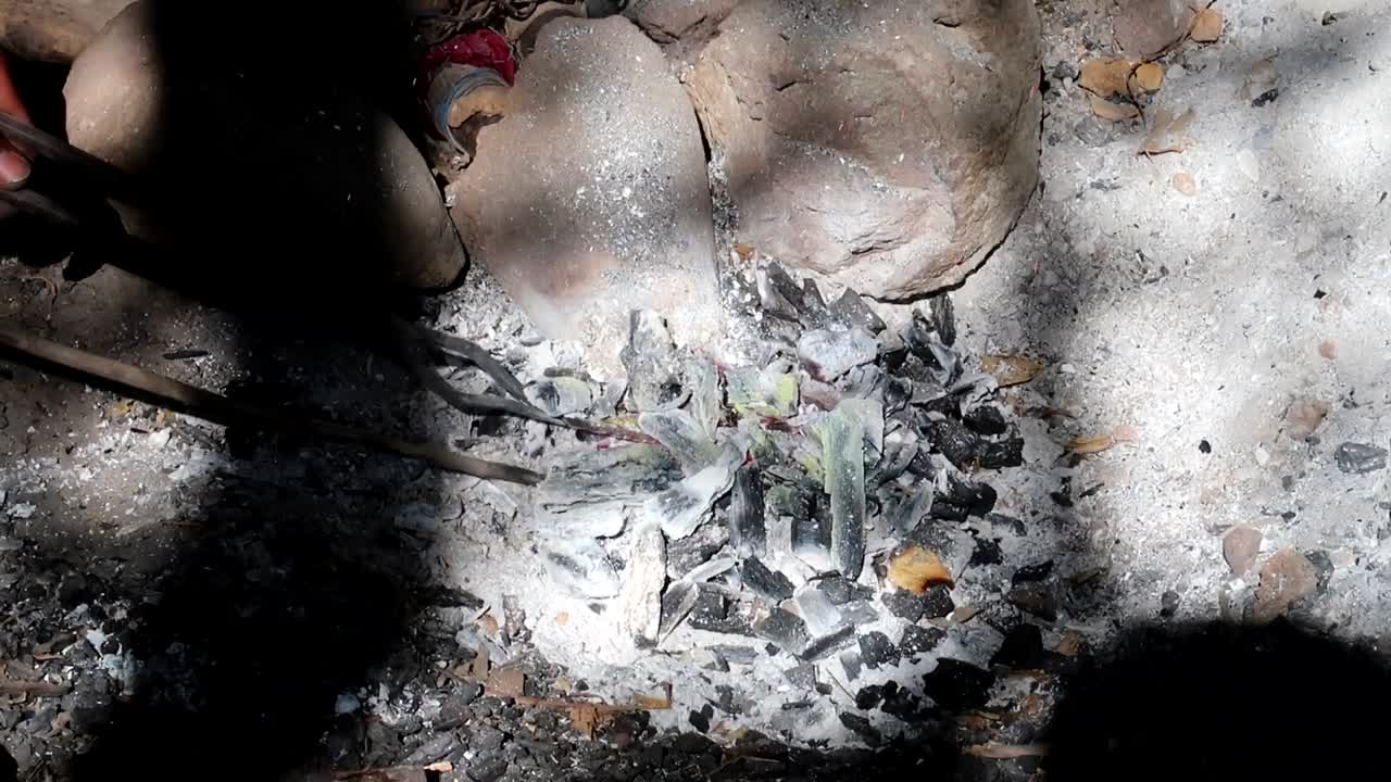 작고 시골 모닥불의 불씨에서 금속을 녹이려는 아프리카 사람들