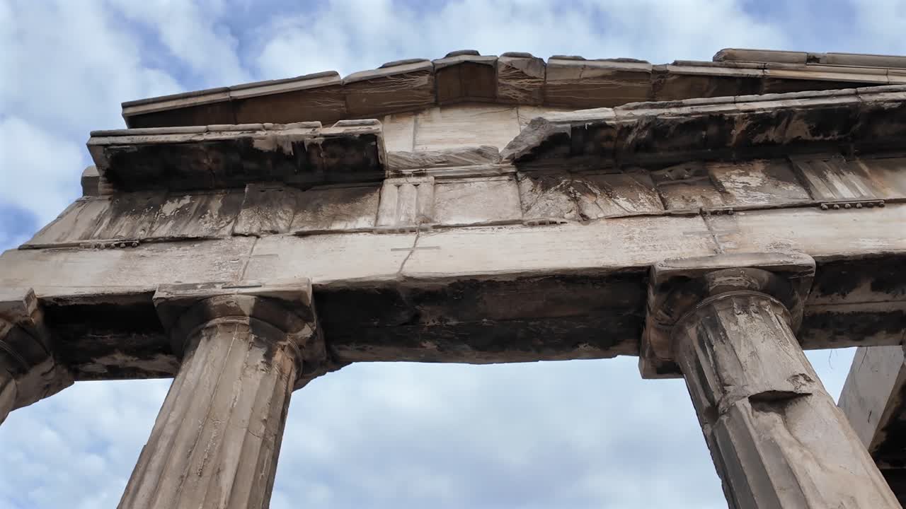 Athens,Gate of Athena Archegetis with Blue Sky and white clouds on the background, pan right, close up view of the gate's arch