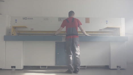 trabajador que opera una máquina de corte de papel