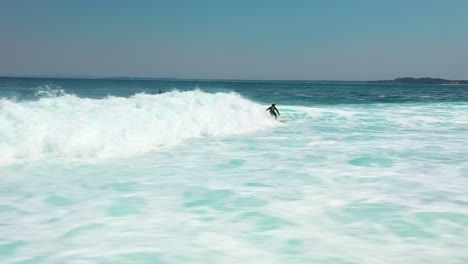 dynamic drone view: surfer slices through a big turquoise barrel wave in jervis bay, australia—super low aerial perspective over ocean, big splash