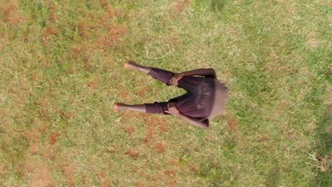 una toma a cámara lenta a vista de pájaro de una joven bailarina africana saltando al aire