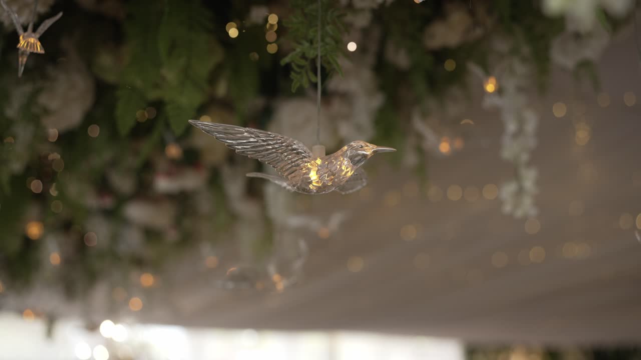 Leuchtendes dekoratives Vogelornament, schwebend zwischen sanften Lichtern