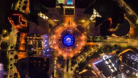 aerial view time lapse of the fountain and traffic in the circle at night at singapore