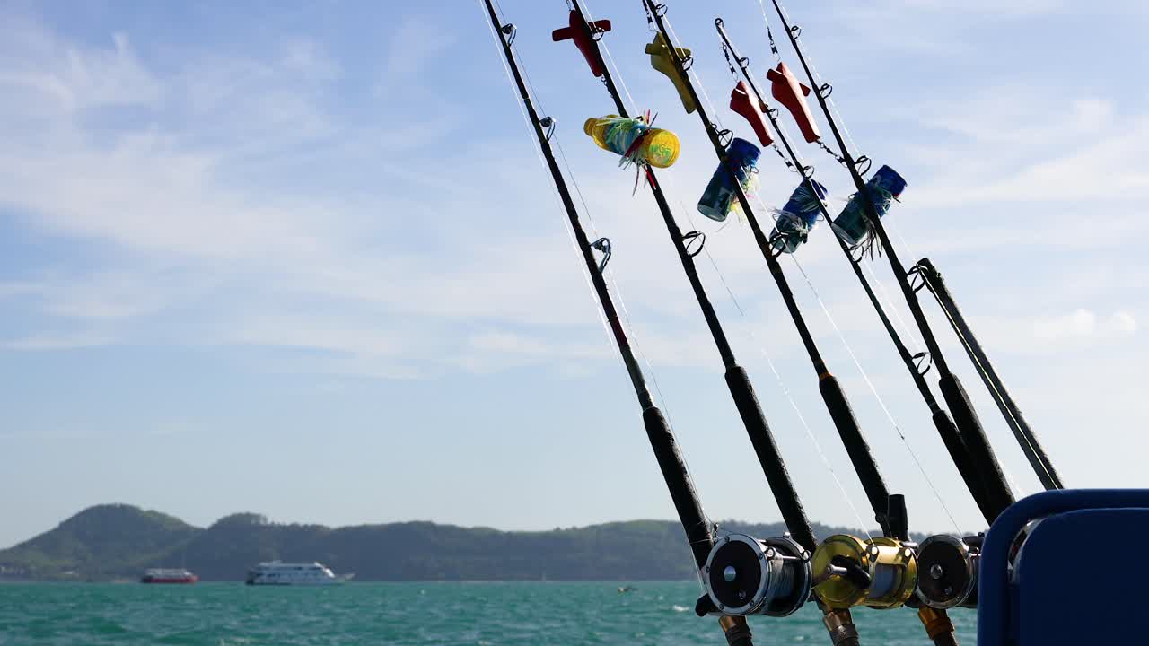 푸켓의 배에서 시 막대기가 부드럽게 흔들리고, 은 하늘 아래 멀리 떨어진 섬들과 함께 평온한 바다 풍경을 포착합니다.