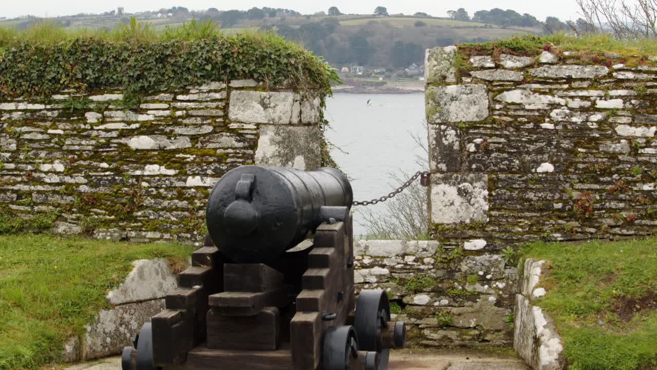 배경 에 세일보트 가 있는 옛 군사 해양 방어 에서 총 을 배치 하는 것