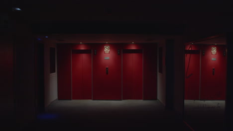 red elevator doors in a dark hallway