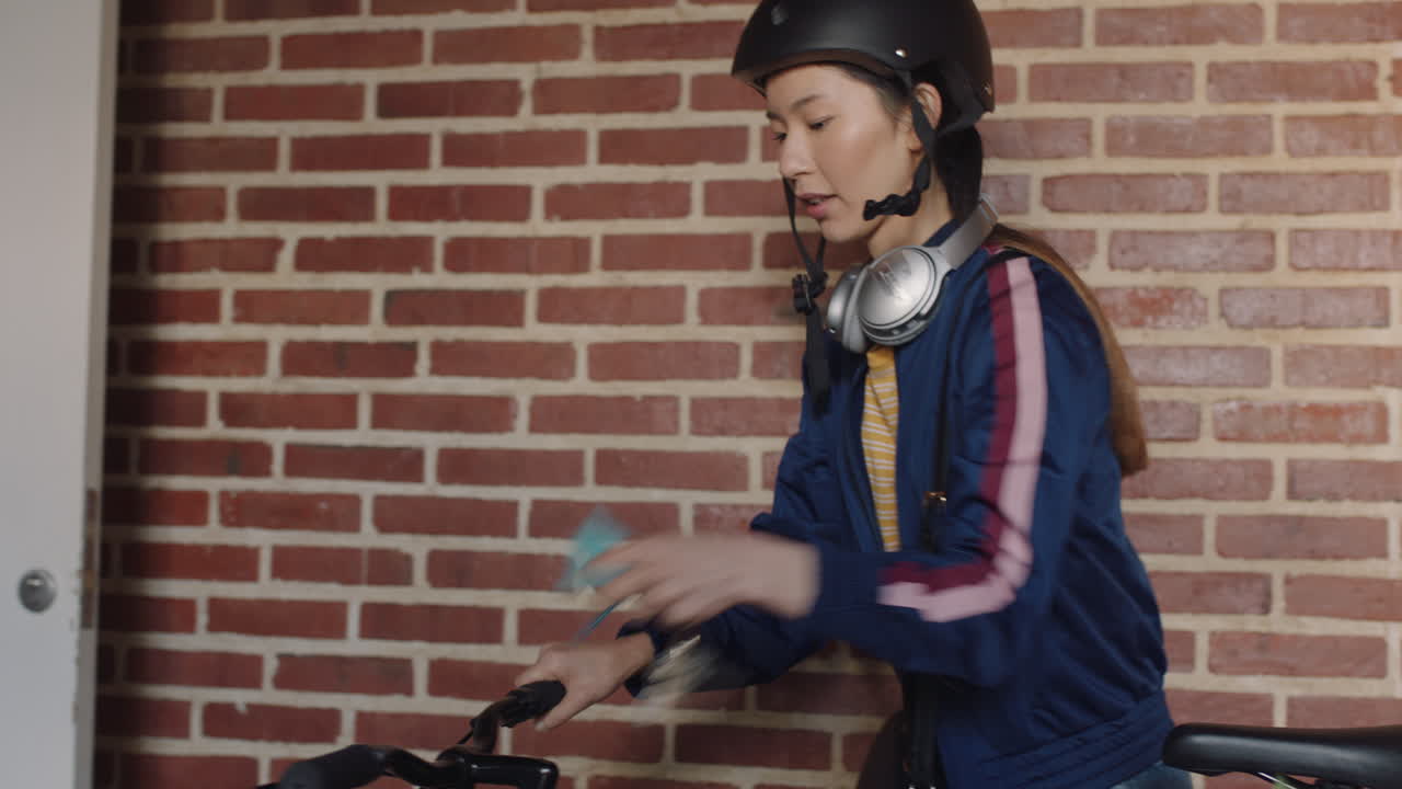 hermosa mujer joven asiática preparándose para salir del apartamento con bicicleta tarde para el trabajo