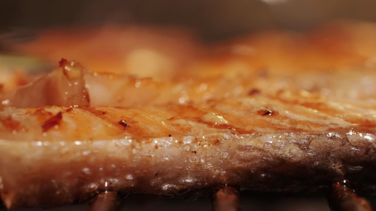 Chef cooking red salmon fish steaks with oil and spices on grill close-up. Prawns on fire throwing them on pan. Making Dorado fishes on frying grill. Restaurant Food concept. Sea food barbecue.
