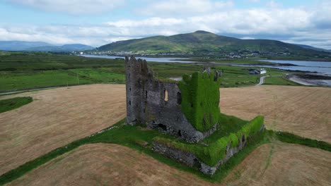 Círculo-Aéreo-Del-Castillo-De-Ballycarbery-Cubierto-De-Hiedra-Cerca-Del-Océano,-Cahersiveen,-Irlanda