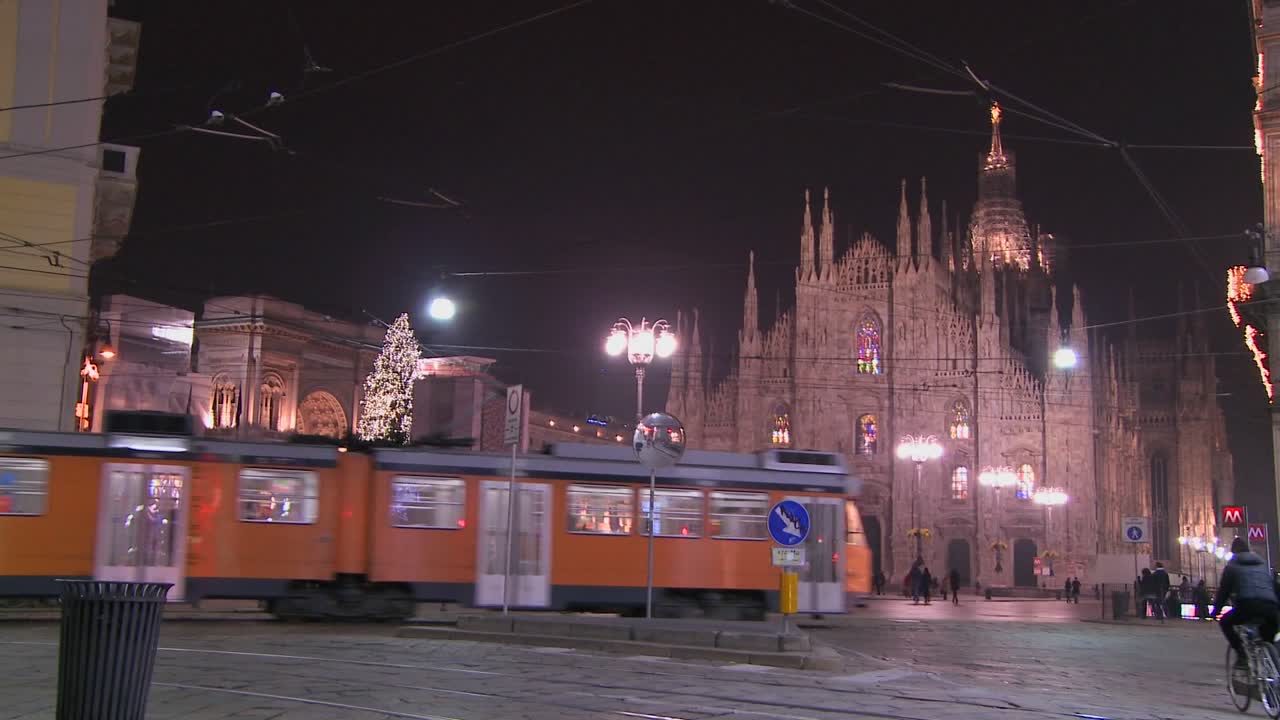 이탈리아 밀라노 두오모 성당 앞 거리에서 밤에 트롤리가 지나간다 1