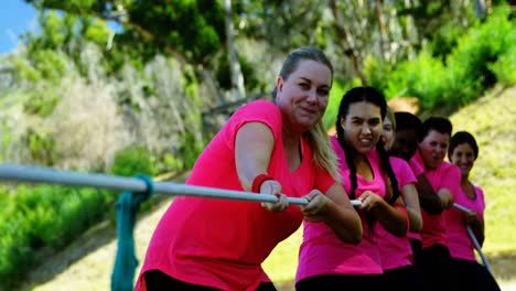 grupo de mujeres jugando al tira y afloja durante una carrera de obstáculos