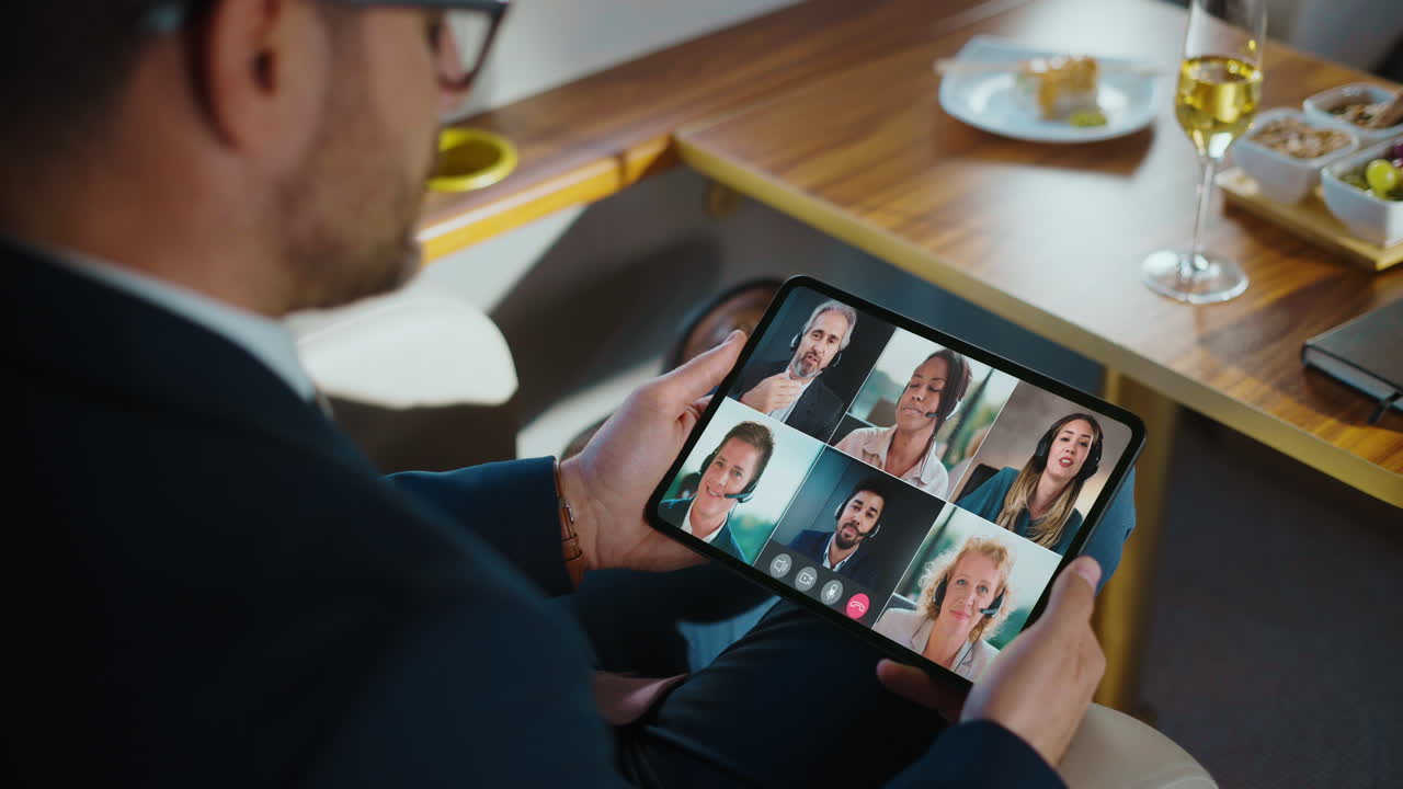 Man holding a tablet with a video conference call